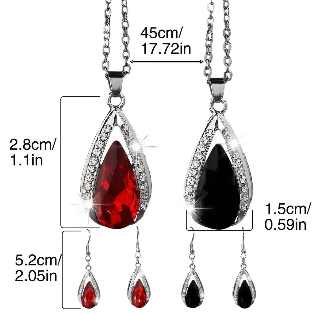 Black and red teardrop-shaped glass pendant necklace and matching earrings set laid flat.
