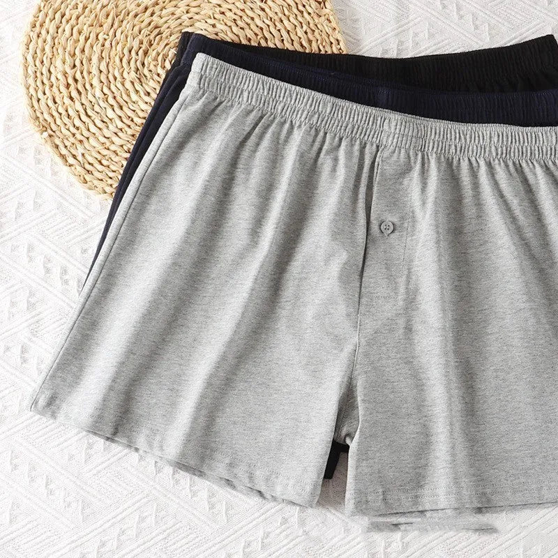 Men's solid colour cotton boxer shorts on a hanger, showing loose fit and high waist.
