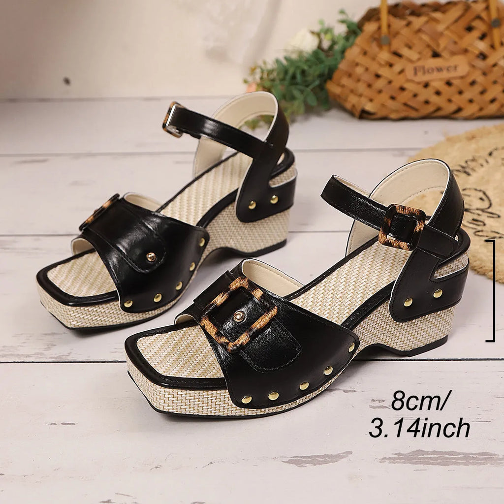 Women's black chunky heel sandals with a square toe and metal buckle fastening on a rubber sole.