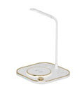 Black three-in-one wireless magnetic charging station with desk lamp and cable on a wooden desk.