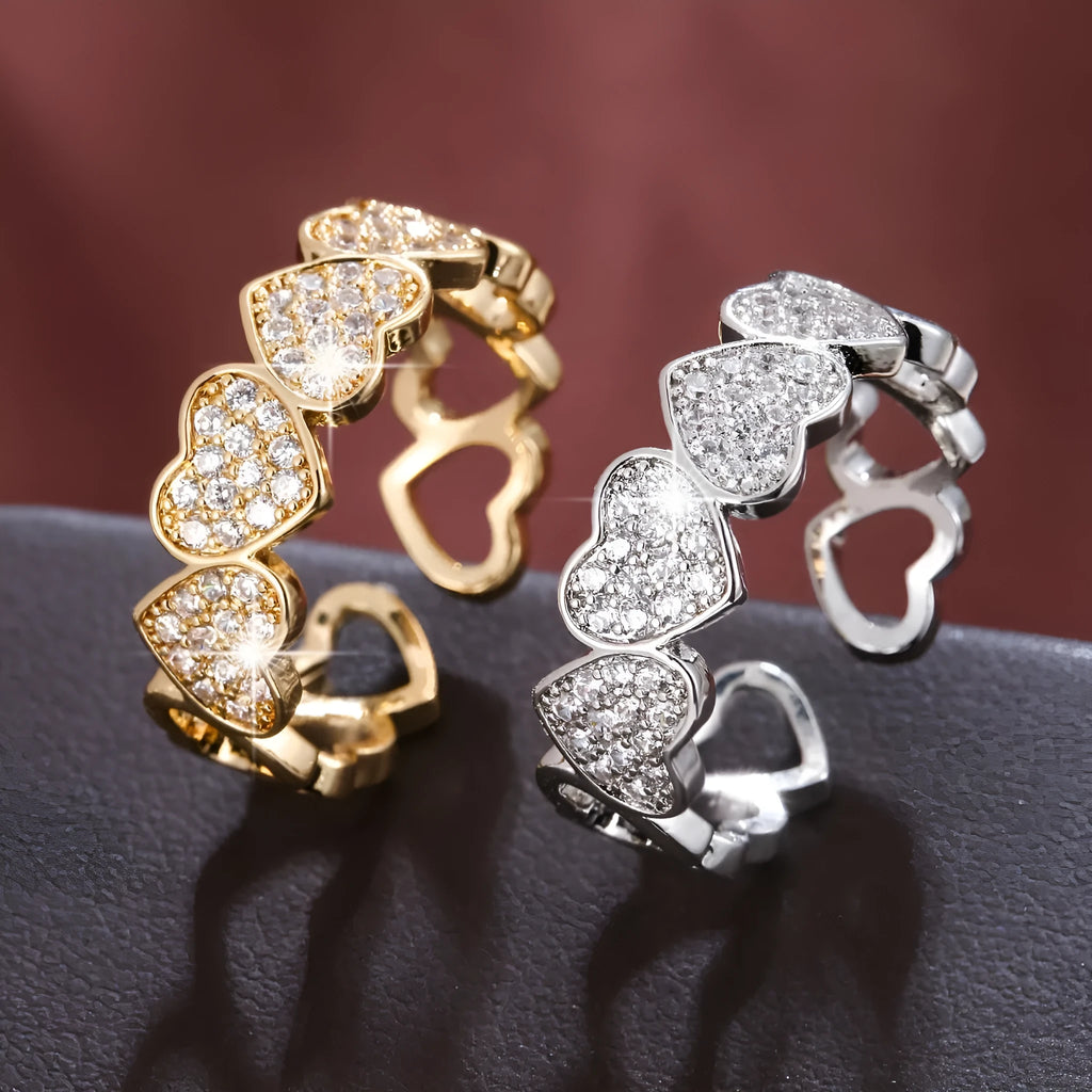 Geometric adjustable opening ring with a love heart detail in a choice of gold or silver tone finish.