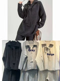 Women's beige knit two-piece set with long-sleeve top and trousers featuring collage stitch detail