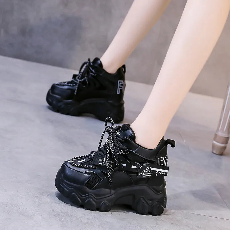 White women's low-top platform sports shoes with a cross-strap over a shallow-cut collar and a thick rubber sole.
