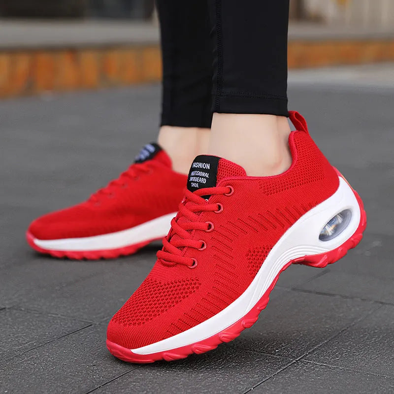 Women's red and black round toe lace-up mesh sneakers on a white background, showing the low-top profile and flat PU sole.