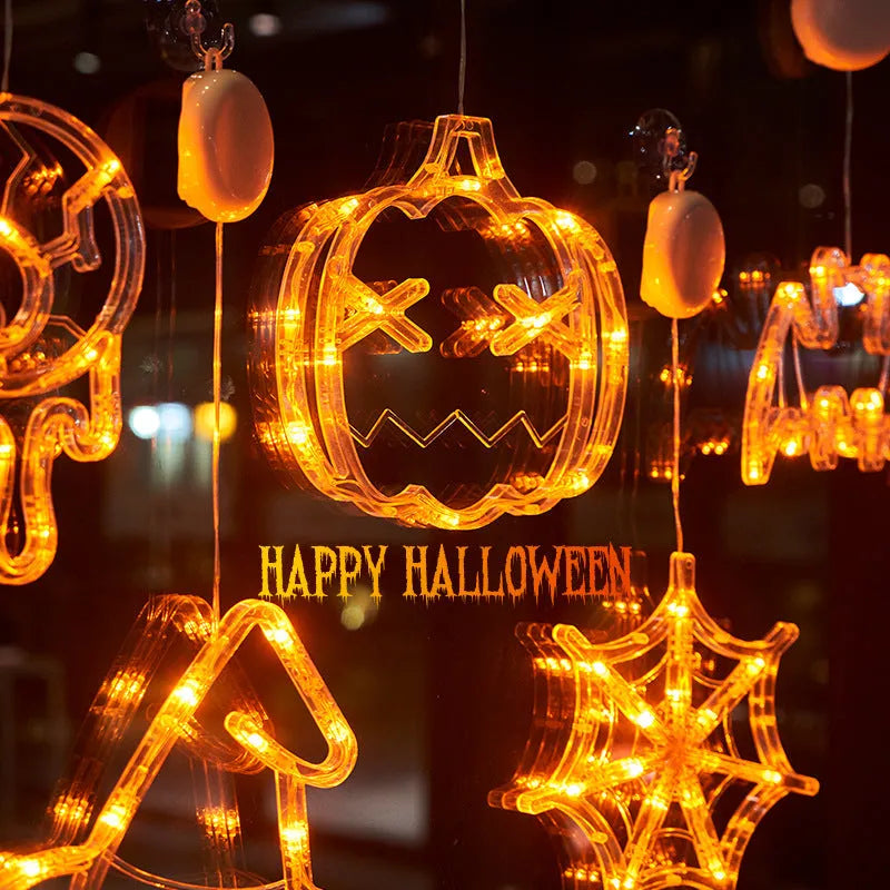 Halloween battery-powered LED window lights with spider, pumpkin and ghost figures hung by suction cups.