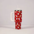 Red and green Christmas pattern stainless steel travel tumbler with handle and straw.