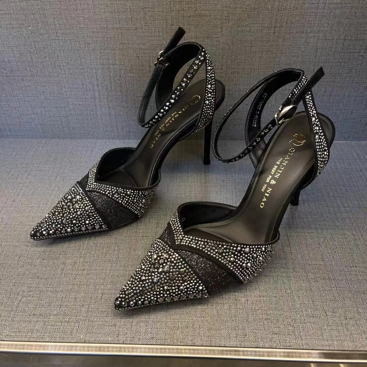 Women's black high heels with hollow red stiletto heel and pointed toe.
