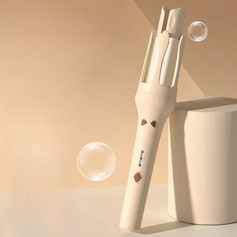White and pink automatic hair curler with a 32mm rotating ceramic barrel and clamp, resting on a table with international power adapters.