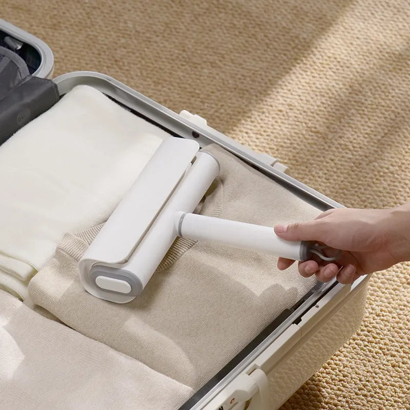 Lint remover roller with plastic handle and tearable paper roll for removing pet hair and dust.