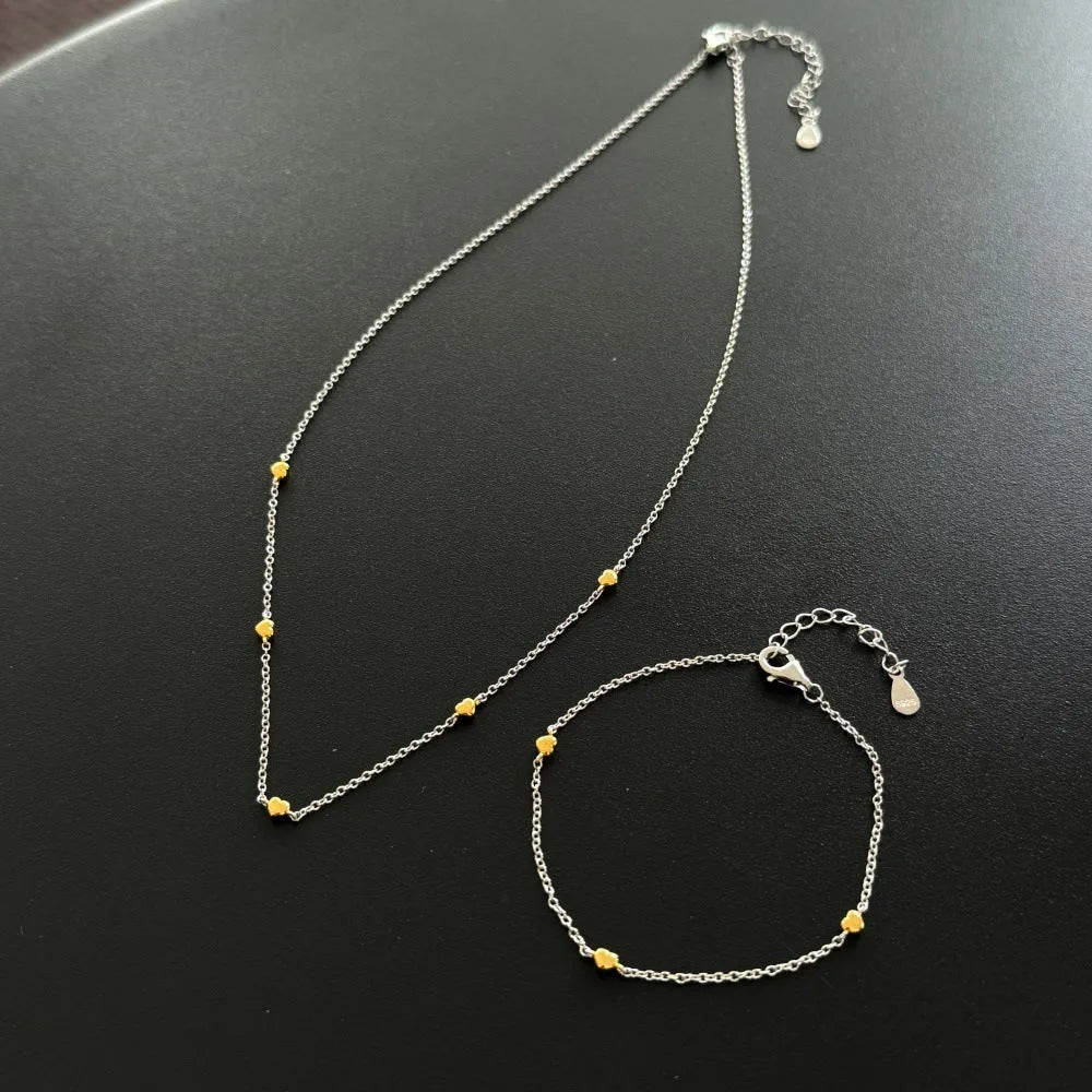 Light luxury silver necklace and bracelet set with platinum electroplated finish on white background