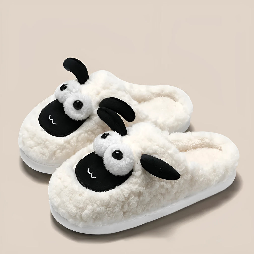 Brown suede slip-on slippers with a light-coloured PVC sole on a wooden floor.