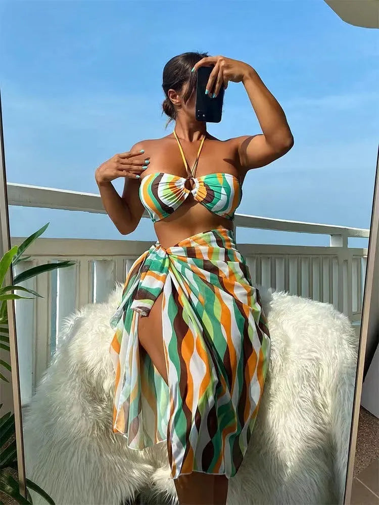 Women's yellow green three-piece bikini set with a beach skirt laid flat