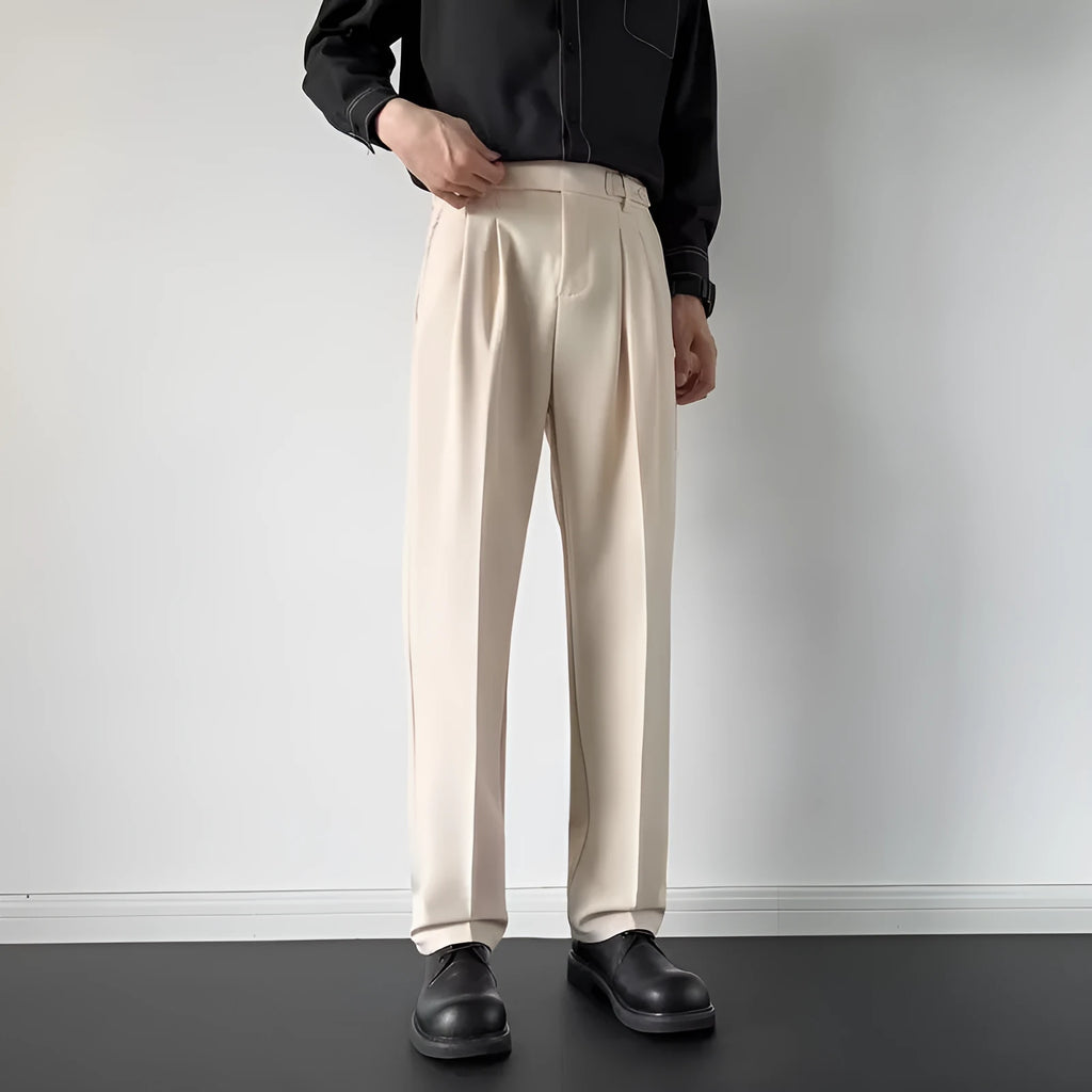 Men's straight leg loose fit suit trousers in apricot colour hanging on a hanger.