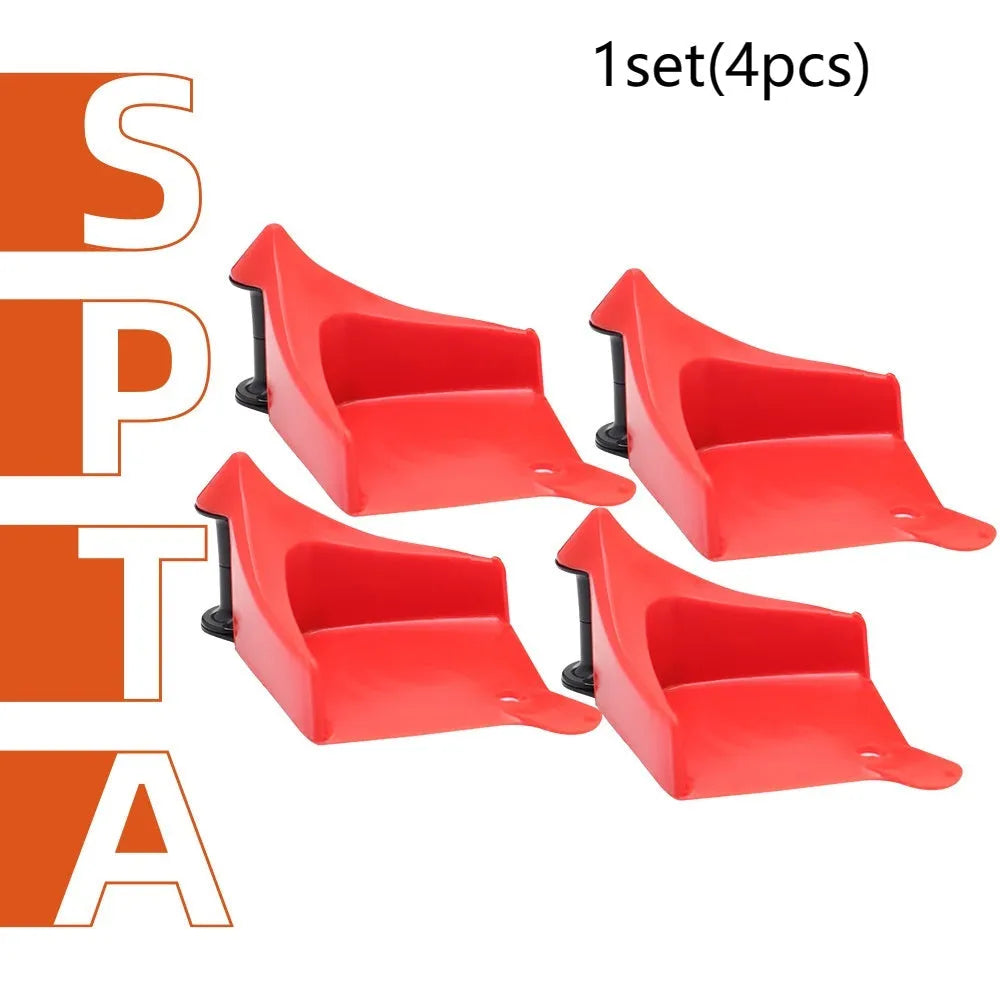 Four red plastic triangular car parking blocks arranged on a grey surface
