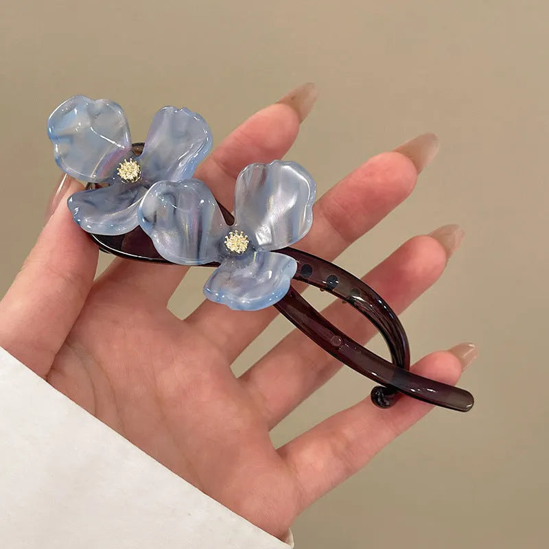 Close-up of a retro-style floral bobby pin hair clip with acrylic petals in a choice of colours.
