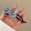 Close-up of a retro-style floral bobby pin hair clip with acrylic petals in a choice of colours.