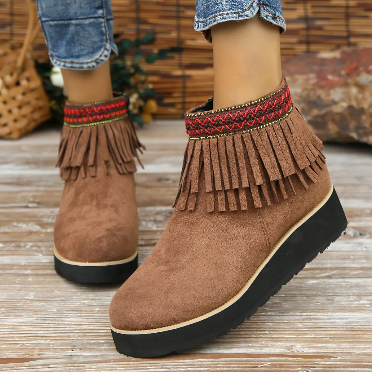 Women's suede ankle boots with a wedge heel, side zipper, and tassel detail in dark brown.