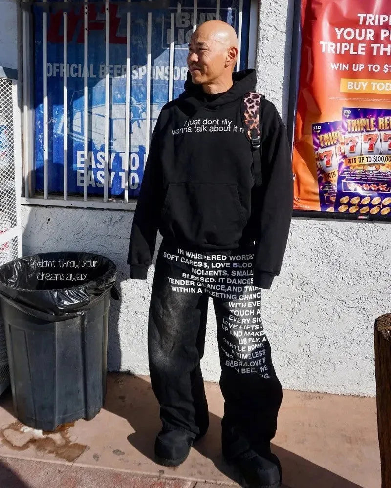 Man modelling black loose wide-leg straight cotton casual trousers with an elasticated waistband.