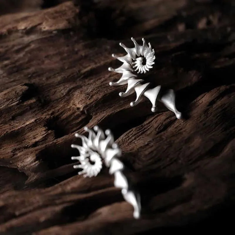 A pair of alloy conch-coloured stud earrings with an irregular three-dimensional shape and a matte finish.