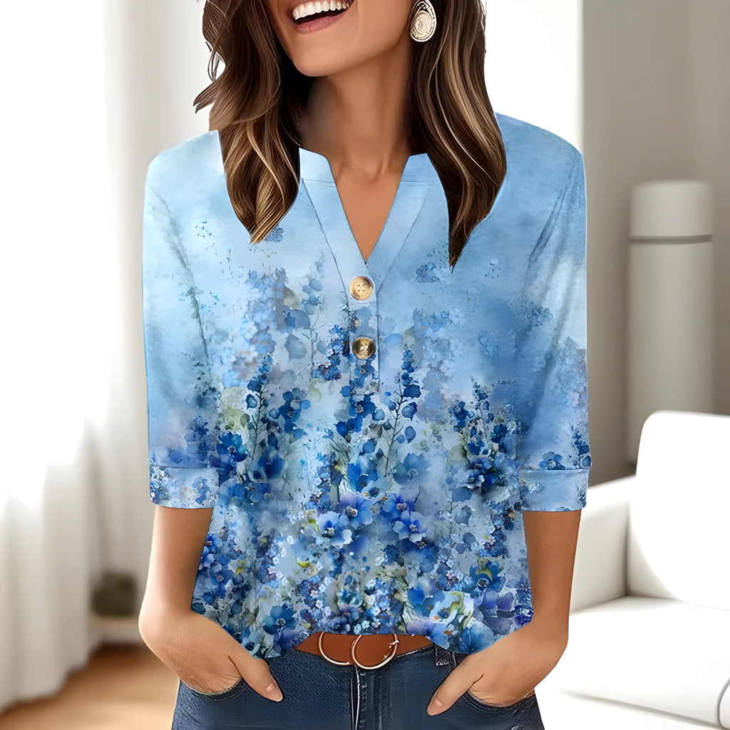 Woman wearing a loose-fit grey V-neck top with a raised white 3D geometric pattern on the front.