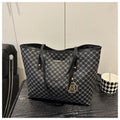 PU leather shoulder bag with adjustable strap in black, shown with visible stitching detail.