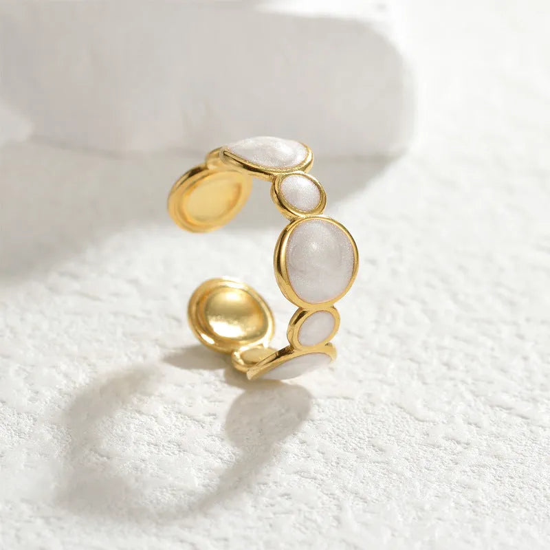 Geometric stainless steel ring with adjustable opening on a plain background.