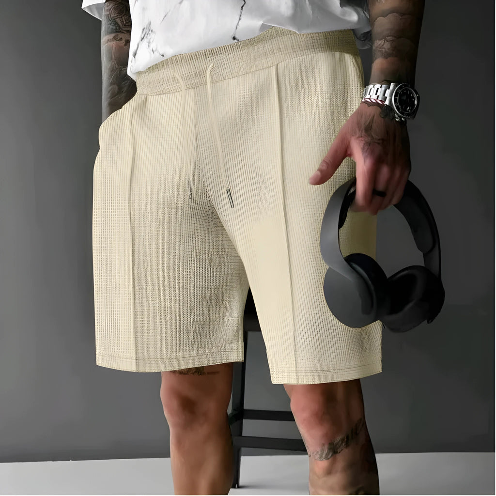 Solid colour five-point polyester sports shorts in khaki with elastic waistband, side view on model