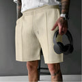 Solid colour five-point polyester sports shorts in khaki with elastic waistband, side view on model