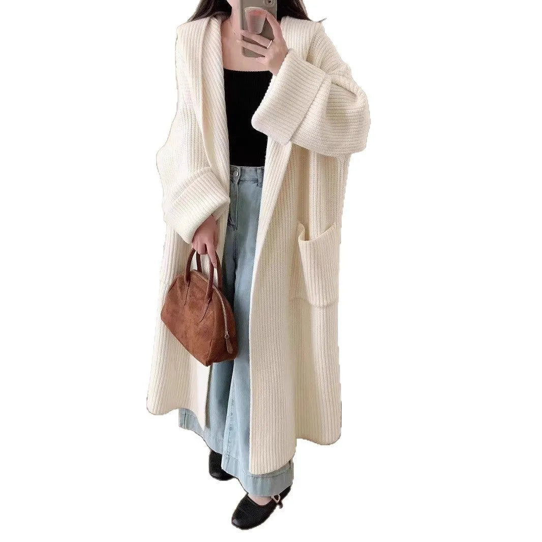Woman wearing a longline loose grey hooded cardigan coat with raglan sleeves.