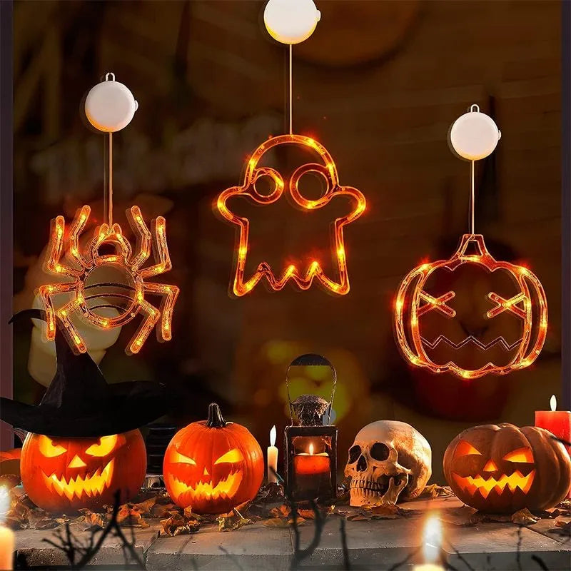 Halloween battery-powered LED window lights with spider, pumpkin and ghost figures hung by suction cups.
