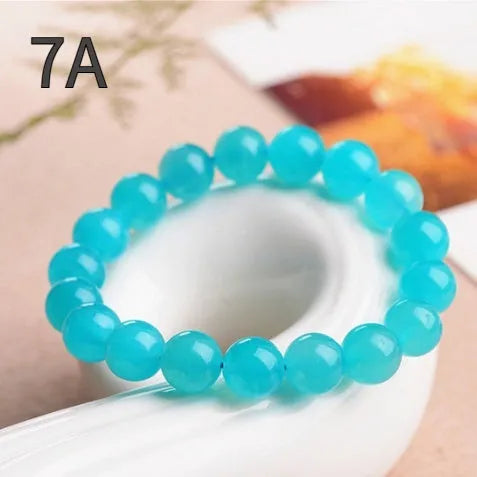 Loose natural blue-green Amazonite beads in various sizes from 6mm to 13mm on a white surface.