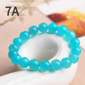 Loose natural blue-green Amazonite beads in various sizes from 6mm to 13mm on a white surface.