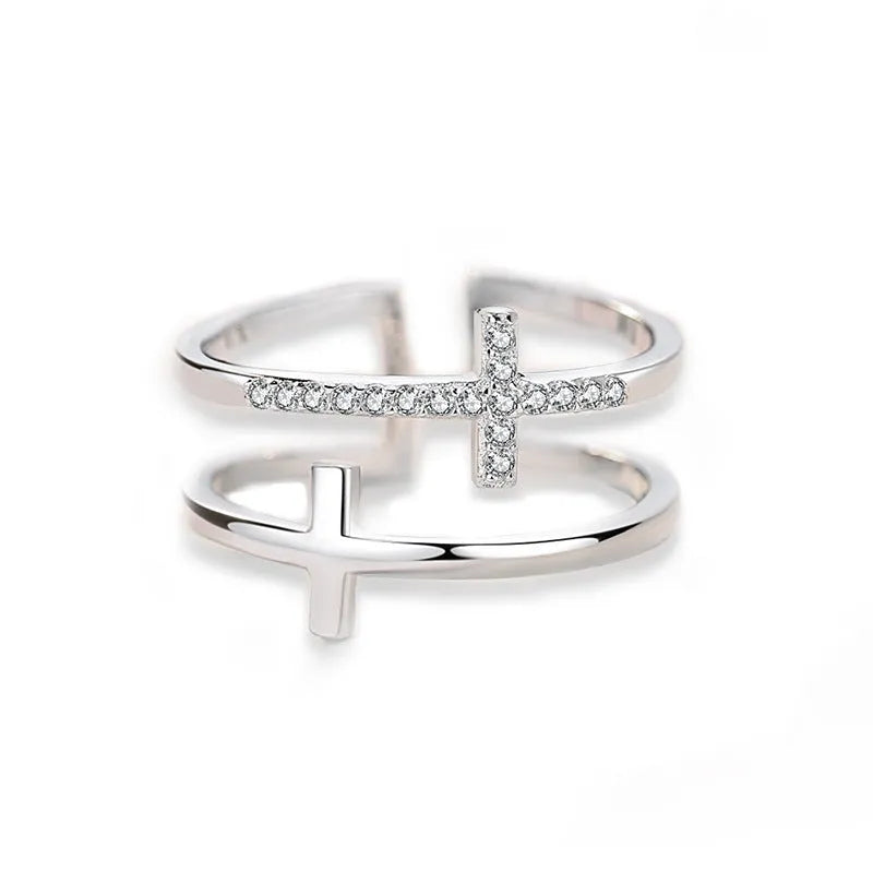 Close-up of a women's adjustable copper ring featuring a miniature double cross design with a zircon stone set in sterling silver.
