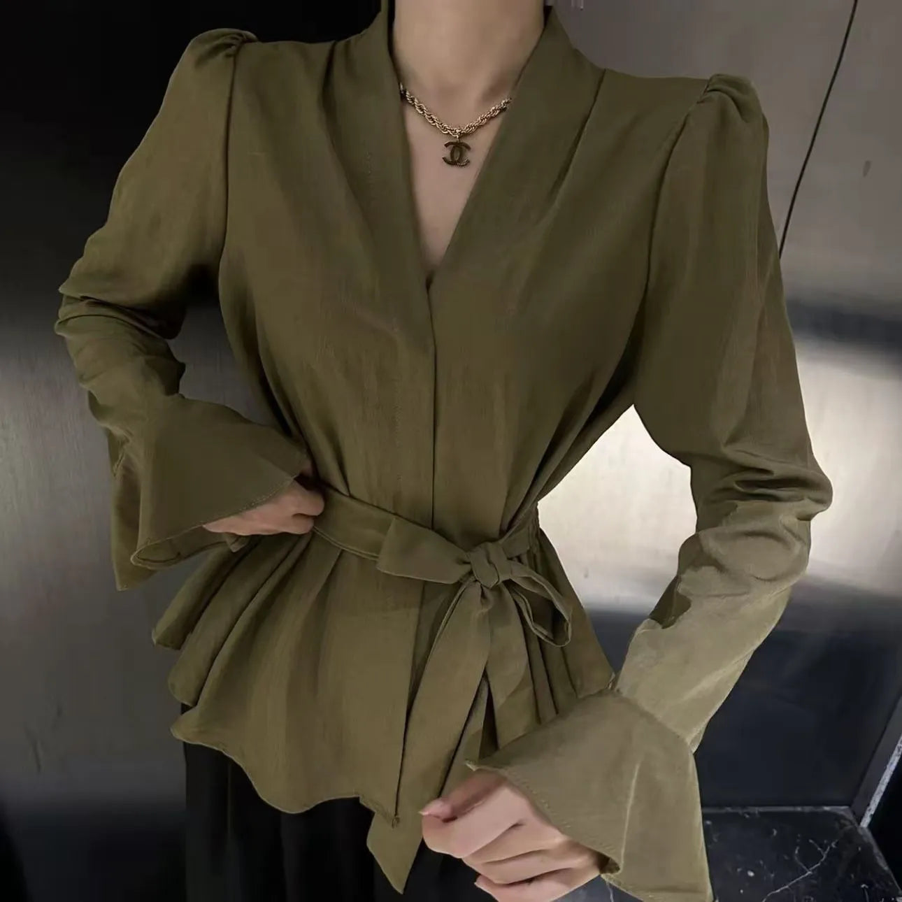Black women's French-style shirt with irregular collar, long bell sleeves and tied front detail.