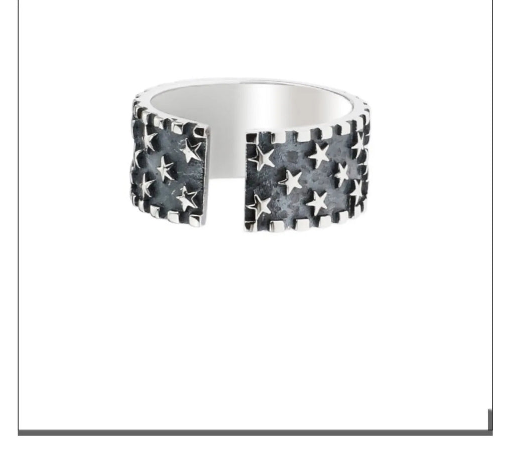 Adjustable sterling silver ring showing multiple five-pointed star geometric pattern on band