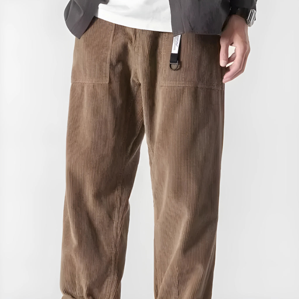 Man wearing loose tapered straight-leg trousers in a dark grey colour with wide legs.