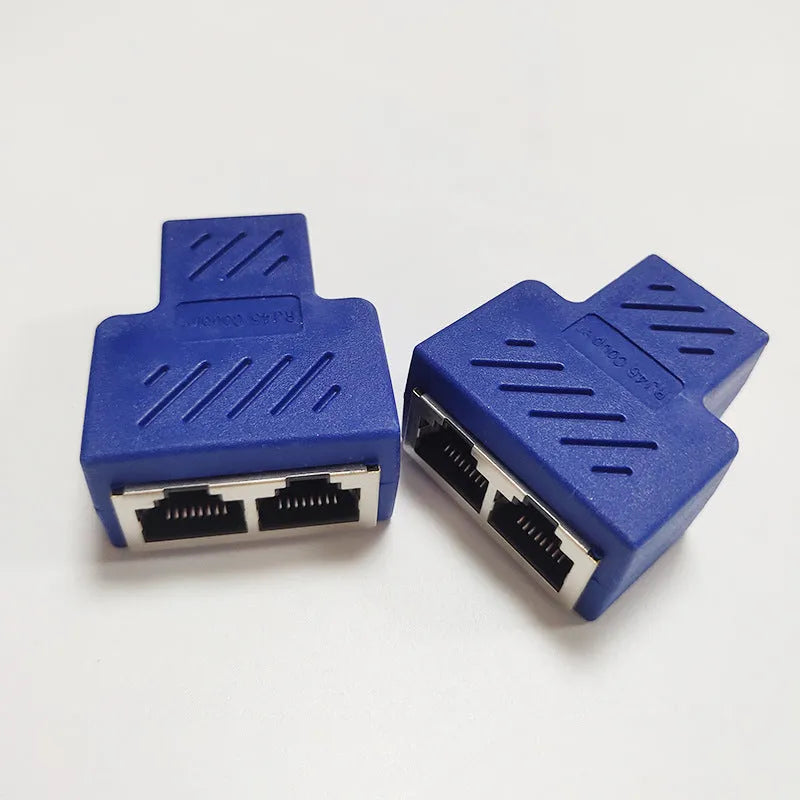 Two white RJ45 three-way tee network cable splitters on a dark surface.