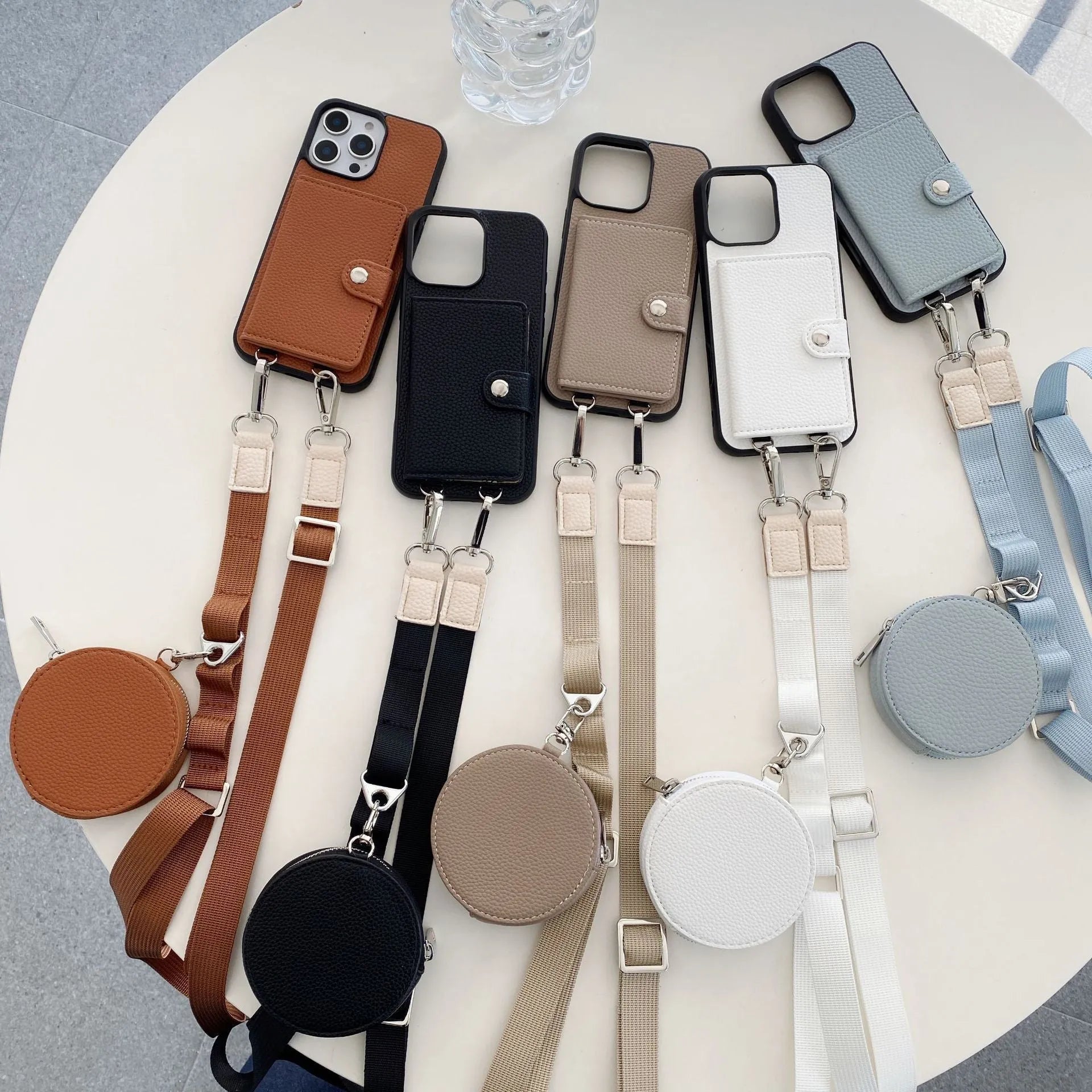 Polycarbonate leather lanyard phone case with card slot for iPhone, shown in black, brown, orange and white.