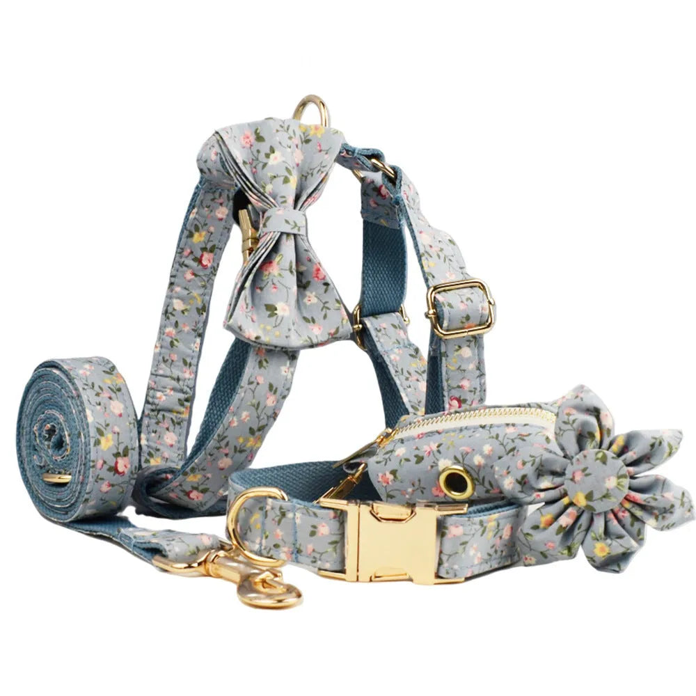 Floral print dog collar and leash set with matching bow, vest, and poop bag holder.