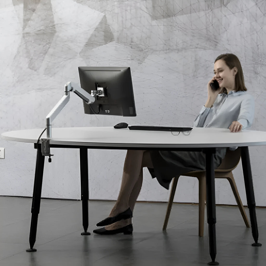 Aluminium alloy laptop stand with an adjustable air pressure arm in black colour on a wooden desk.