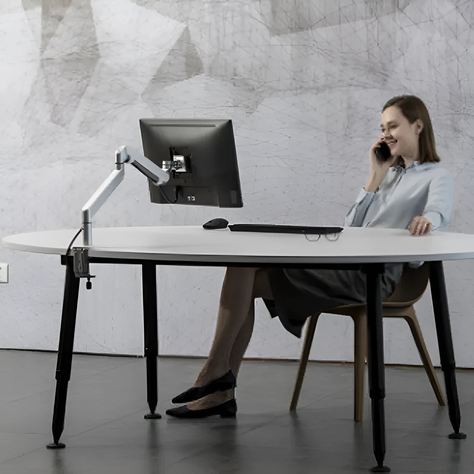 Aluminium alloy laptop stand with an adjustable air pressure arm in black colour on a wooden desk.