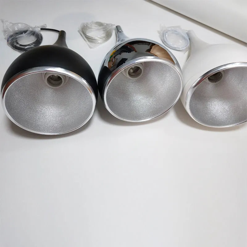 Minimalist iron pendant chandelier with three black lamp heads on a long disc fitting.