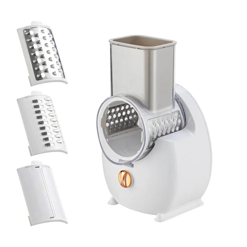 White electric vegetable slicer with rotary grater, suction base, and multiple blades on a kitchen counter.