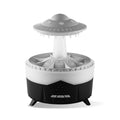 White UFO-shaped cloud humidifier with mist and soft blue night light on a wooden table