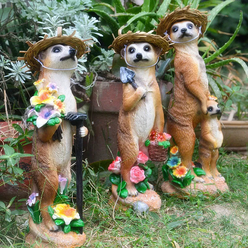 Three straw hat mongoose garden ornaments including mother and child grouping plus figures with rake and shovel