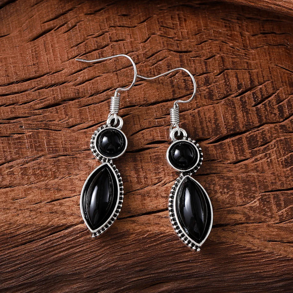 A pair of vintage-style geometric pendant earrings with purple and black stones on a zinc alloy frame.
