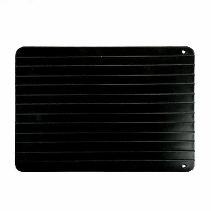 Black aluminium fast defrost tray for thawing frozen food on a kitchen counter.