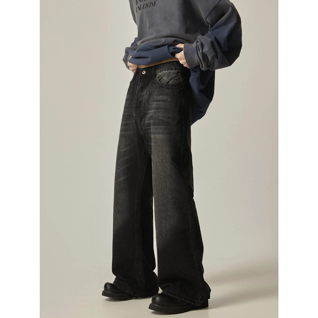 A pair of black loose-fit straight-leg jeans with a retro style on a white background.
