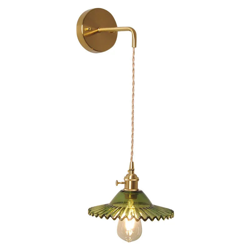 Retro brass wall lamp with a white glass lotus flower shade mounted on a beige wall.