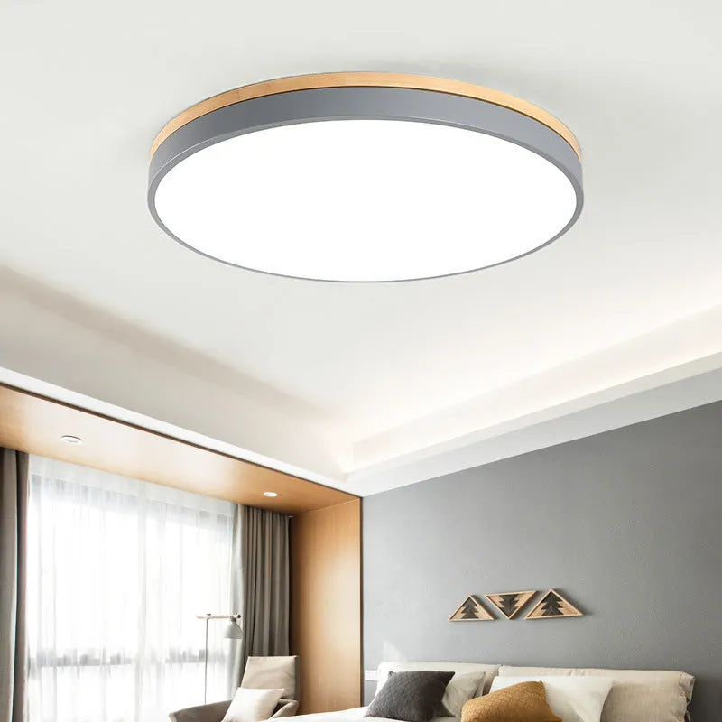 Round Nordic style ceiling lamp with solid wood and iron frame, white acrylic diffuser, shown in a living room setting.